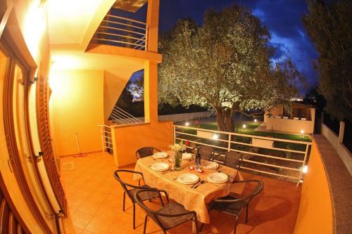 a table and chairs on a patio at night at Apartments Villa Mareta in Sukošan
