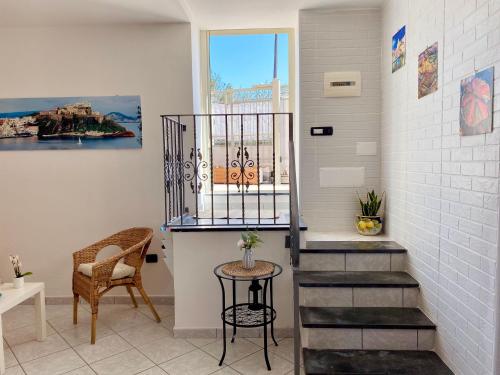 a staircase in a room with a table and a chair at Il Riccio Apartment in Procida