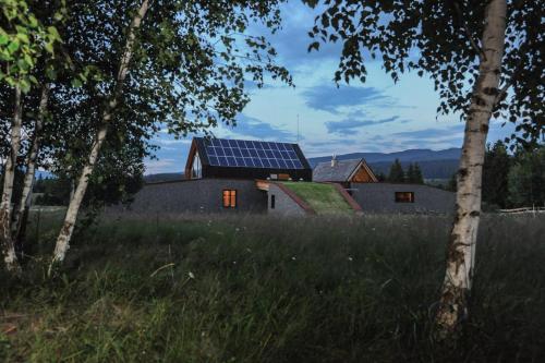a house with solar panels on the side of it at Beechtree Property in Izvoare