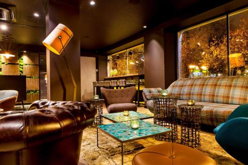 a living room with couches and chairs and tables at Motel One Edinburgh-Royal in Edinburgh