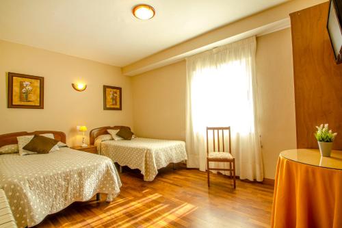 um quarto de hotel com duas camas e uma janela em Hostería Fimar em Ubiarco
