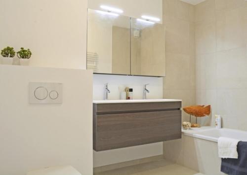 a bathroom with a sink and a toilet and a tub at EastDune in Oostduinkerke