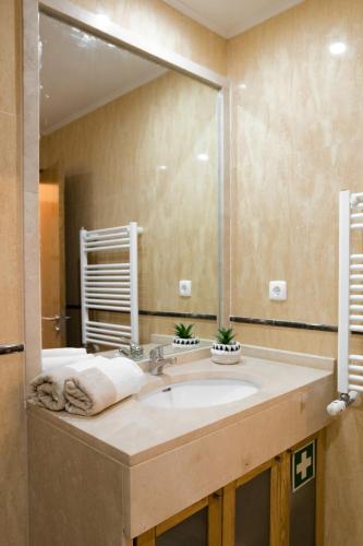 a bathroom with a sink and a large mirror at Casa amigavel do Mar in Sesimbra
