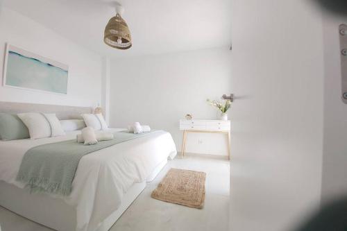 Dormitorio blanco con cama y mesa en Apartment Cala Torta with Pool and Terrace in Canyamel, en Capdepera