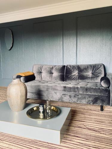a living room with a couch and a table with a vase at Hotel Natura Residence Business&SPA in Siewierz