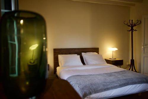 ein Schlafzimmer mit einem Bett mit weißen Laken und Kissen in der Unterkunft LA PETITE MAISON DANS LA PRAIRIE in Mézilles