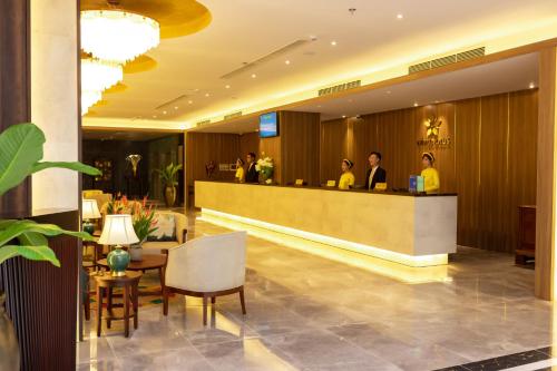 a lobby of a hotel with people at a counter at White Lotus Hue Hotel in Hue
