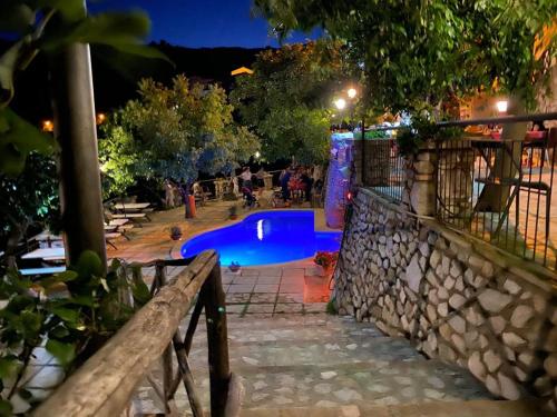 a swimming pool at night with people around it at One bedroom appartement with sea view shared pool and enclosed garden at Badolato in Badolato