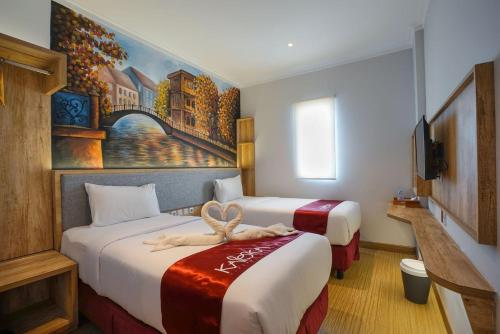 una habitación de hotel con 2 camas y un cuadro en la pared en Kaloka Airport Hotel, en Labu Sumbawa