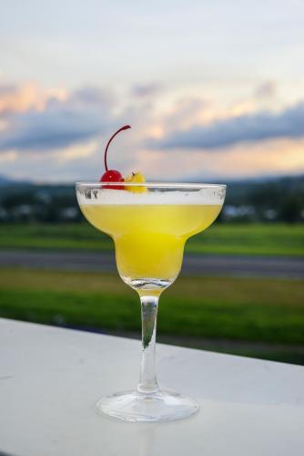 a martini glass with a cherry on a table at Kaloka Airport Hotel in Labu Sumbawa