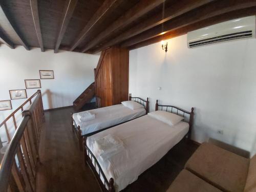 two twin beds in a room with a staircase at Litsa Holiday Home in Kalathos