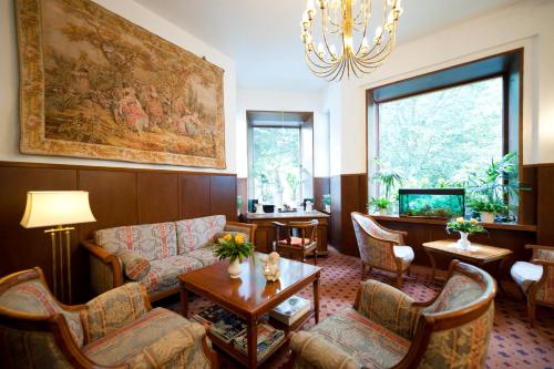 a living room with a couch and chairs and a table at Hotel Spöttel in Bad Nauheim