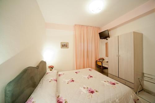 a small bedroom with a bed with flowers on it at Hotel Il Quadrifoglio in Cascia