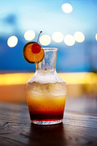 a glass vase with a drink with an orange slice at Kaloka Airport Hotel in Labu Sumbawa