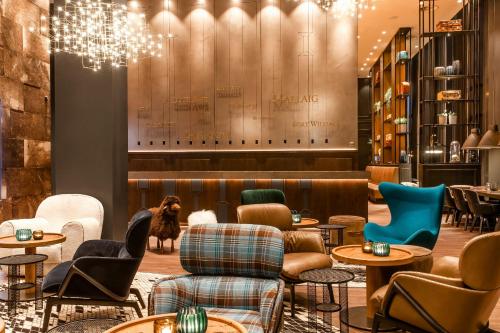 a lobby with tables and chairs and a dog in the background at Motel One Glasgow in Glasgow