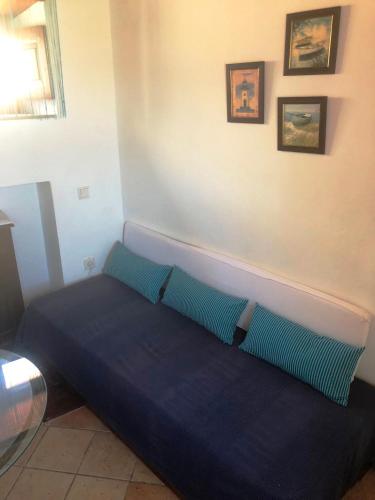 a blue bed in a room with pictures on the wall at Machi's House in Plaka Milou