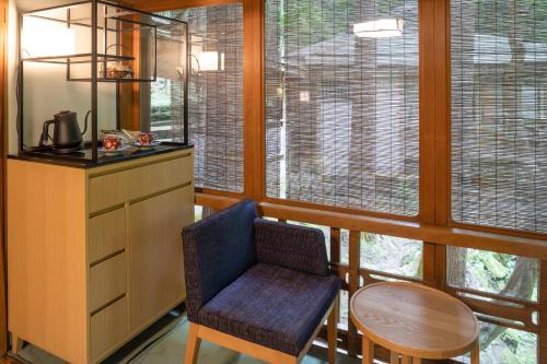 a kitchen with a table and a chair and some windows at Tsukihitei in Nara