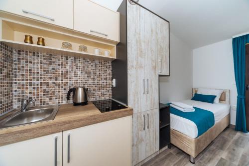 eine Küche mit einem Waschbecken und ein Bett in einem Zimmer in der Unterkunft Altea in Šušanj