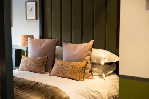 a bed with several pillows on top of it at Mason's Arms in Bowland Bridge