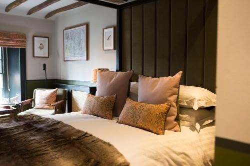 a bedroom with a large bed with pillows at Mason's Arms in Bowland Bridge
