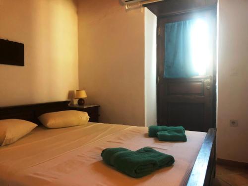 two green towels sitting on top of a bed at Machi's House in Plaka Milou