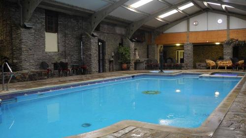 a large blue swimming pool in a building at Trimstone Manor Hotel in West Down
