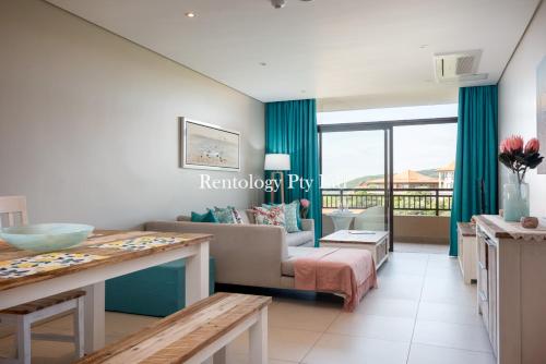 a living room with a couch and a table at Gorgeous 1 Bed Zimbali Suites Sea View in Ballito