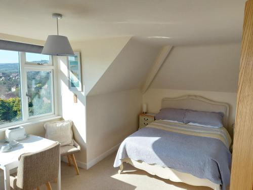 a bedroom with a bed and a table and a window at Aldebaran B&B in Whitby