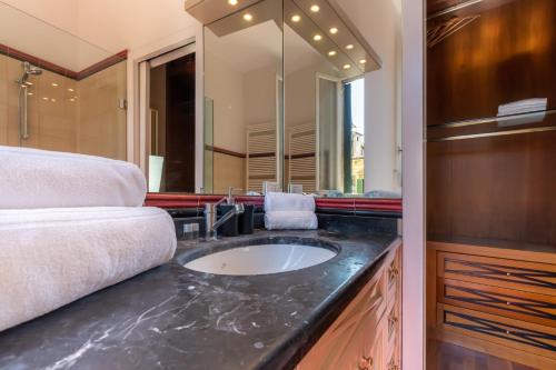 een badkamer met een wastafel en een grote spiegel bij Residenza Girardi in Verona