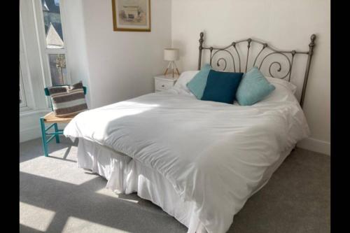 una camera da letto con un grande letto bianco con cuscini blu di No43: Versatile 4BR coastal home with summer house a Cowes