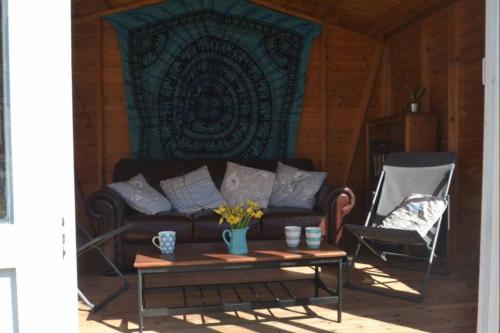 a living room with a couch and a table and a chair at No43: Versatile 4BR coastal home with summer house in Cowes