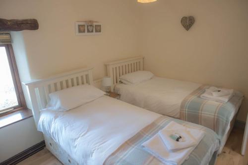 two twin beds in a room with a window at The Horse and Jockey in Tideswell