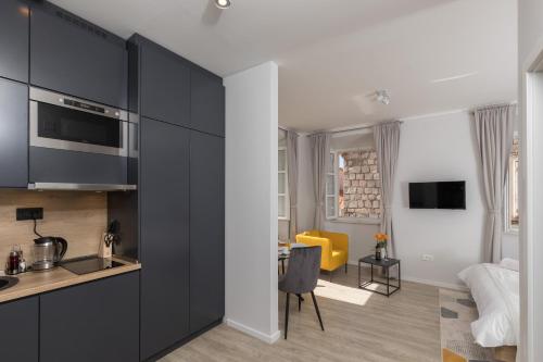 cocina con armarios negros y sala de estar. en Apartments Urbis, en Dubrovnik