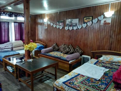 een woonkamer met 2 bedden en een tafel bij Vamoose Himalayan Viewpoint in Ravangla