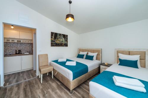 um quarto de hotel com duas camas e uma cozinha em Altea em Šušanj
