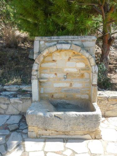 a stone fireplace in the middle of a patio at Zeus Traditional House in Mitrópolis