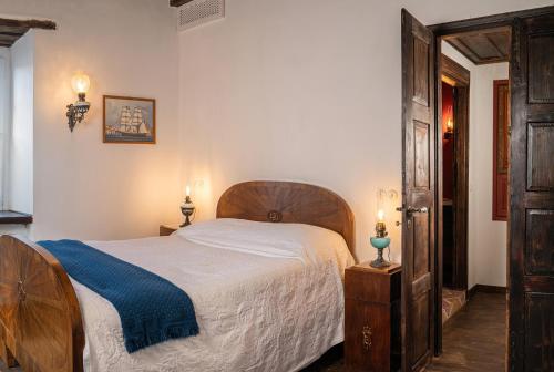 a bedroom with a bed with a blue blanket at The 1813 Painter's Villa by Neuvel in Galaxidhion