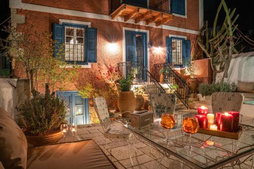 a table with candles on it in front of a building at The 1813 Painter's Villa by Neuvel in Galaxidhion