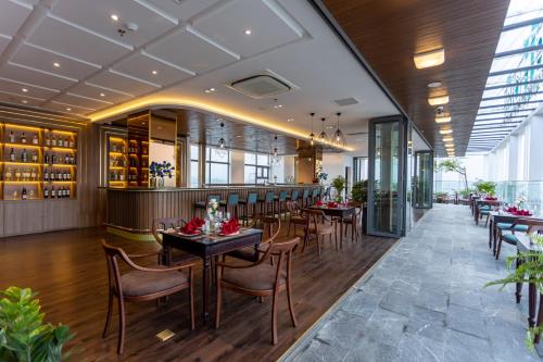 a restaurant with tables and chairs and a bar at White Lotus Hue Hotel in Hue