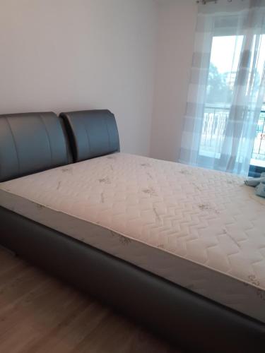a bed in a room with a mattress at Ezüst Apartman in Siófok