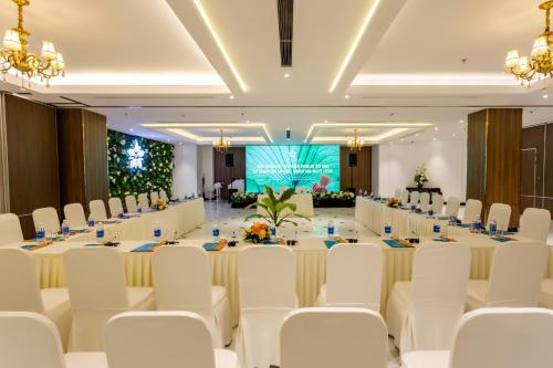 a conference room with a long table and white chairs at White Lotus Hue Hotel in Hue
