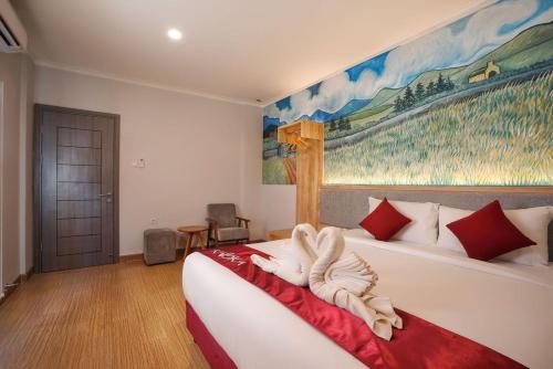 a bedroom with a bed and a painting on the wall at Kaloka Airport Hotel in Labu Sumbawa