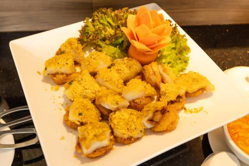 a white plate of food with broccoli on a table at White Lotus Hue Hotel in Hue