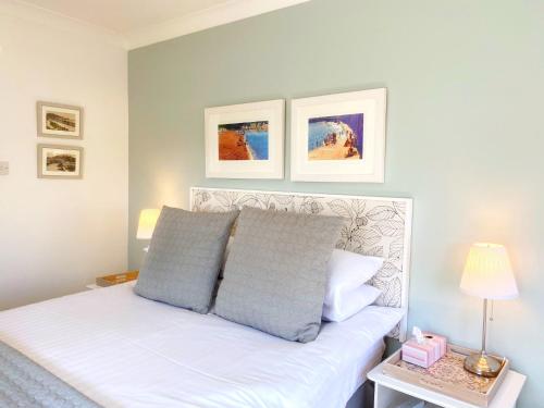 a bedroom with a white bed with two pillows at Braeside Luxury Holiday Home in Torquay