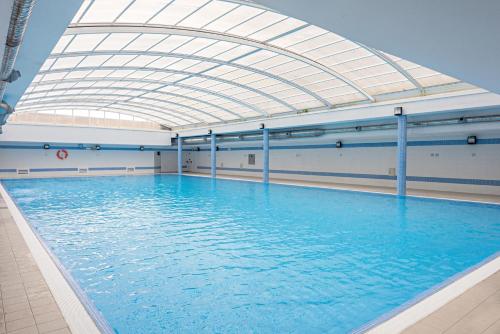an indoor swimming pool with an arched ceiling at BARRAMARES 5 - 4ºandar PISCINA EXTERIOR VISTA MAR in Ovar