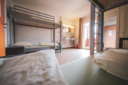 a bedroom with two bunk beds and a hallway at Arosa Mountain Lodge in Arosa