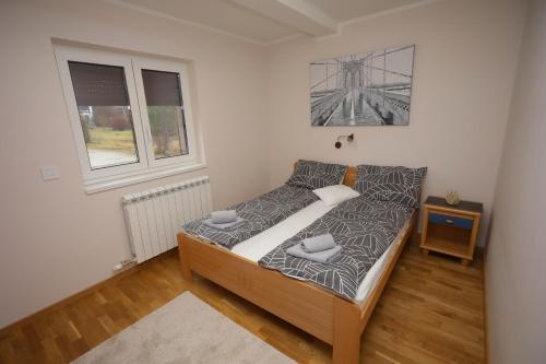 a small bedroom with a bed and a window at Mipet apartmani in Zlatibor