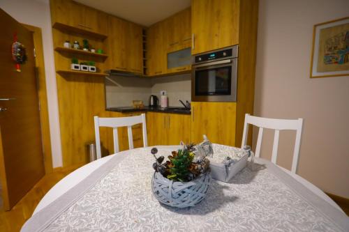 a kitchen with a table with a vase of flowers on it at Mipet apartmani in Zlatibor