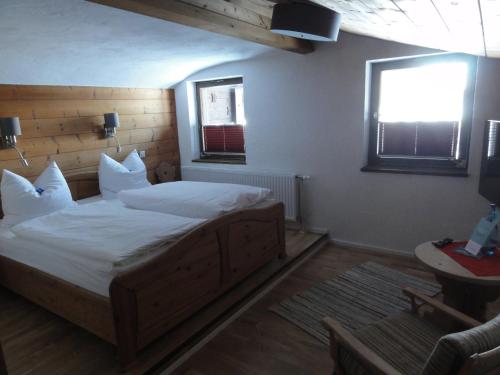 a bedroom with a bed with white sheets and a window at Quartier Severin in Berwang