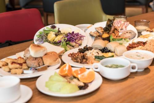 a wooden table with plates of food on it at Inhouse Hotel Yehliu in Wanli